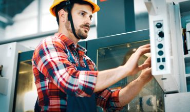 industry-worker-entering-data-in-cnc-machine-at-fa-KMXEVL4.jpg